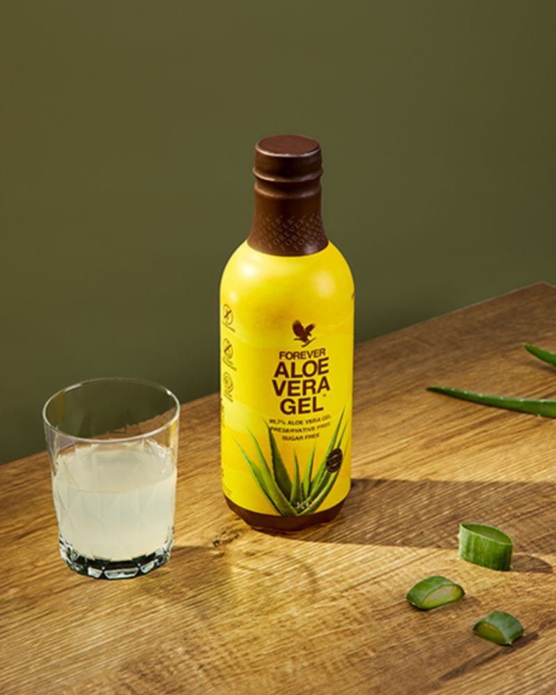 Bidon d'Aloe Vera Gel sur la table avec un verre servi